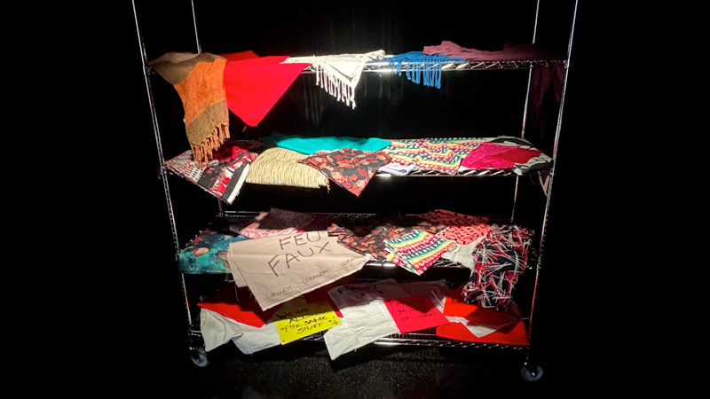 Une étagère en métal avec des tissus colorés ou à motif.