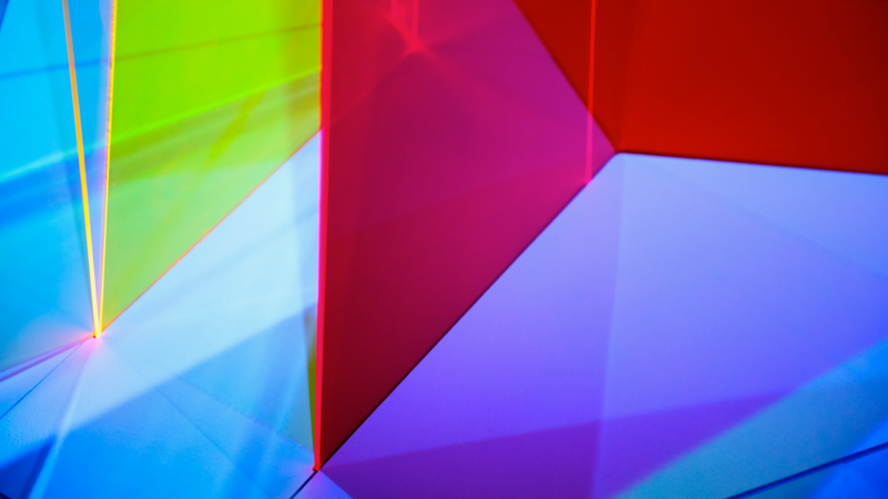 Gros plan d’une lumière reflétant sur des Plexiglas colorés.